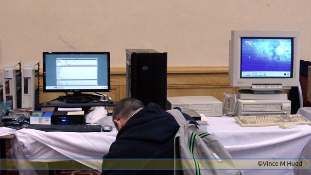 Iconbar's Mark Stephens kneeling at the holy altar of RISC OS - okay, the charity stand - at Wakefield 2022